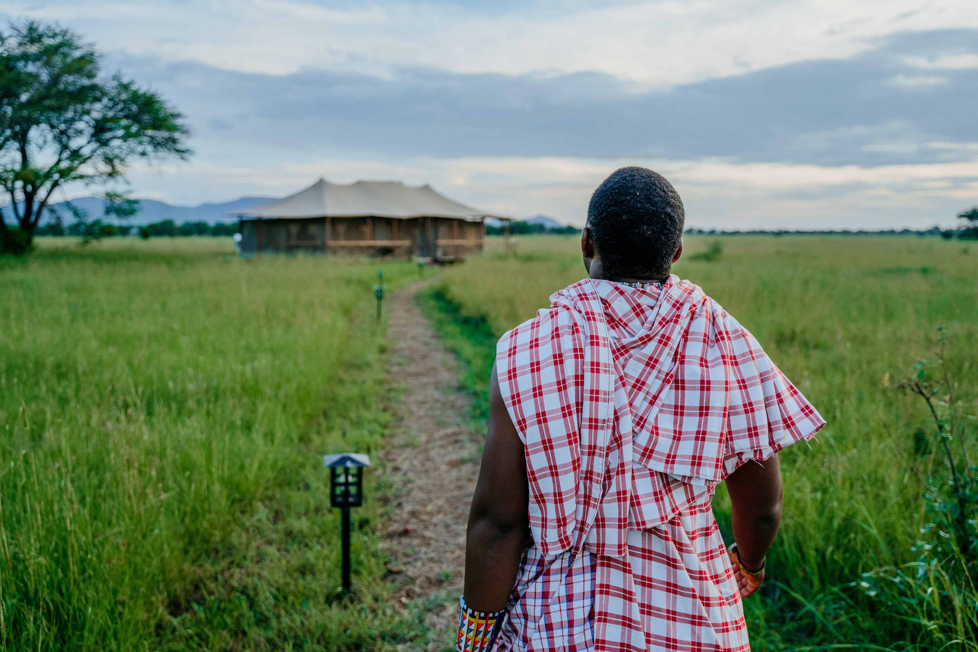 A member of the team walking through a Tanzania camp landscape